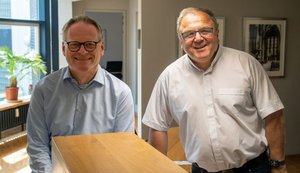 Ulrich Fiege und Hans-Bernd Köppen stehen nebeneinander in einem Büroraum.